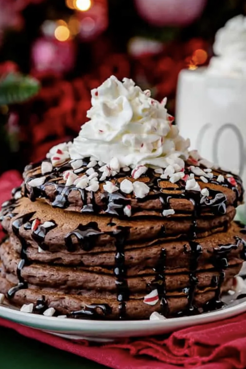hot chocolate pancakes in a stack with whipped cream