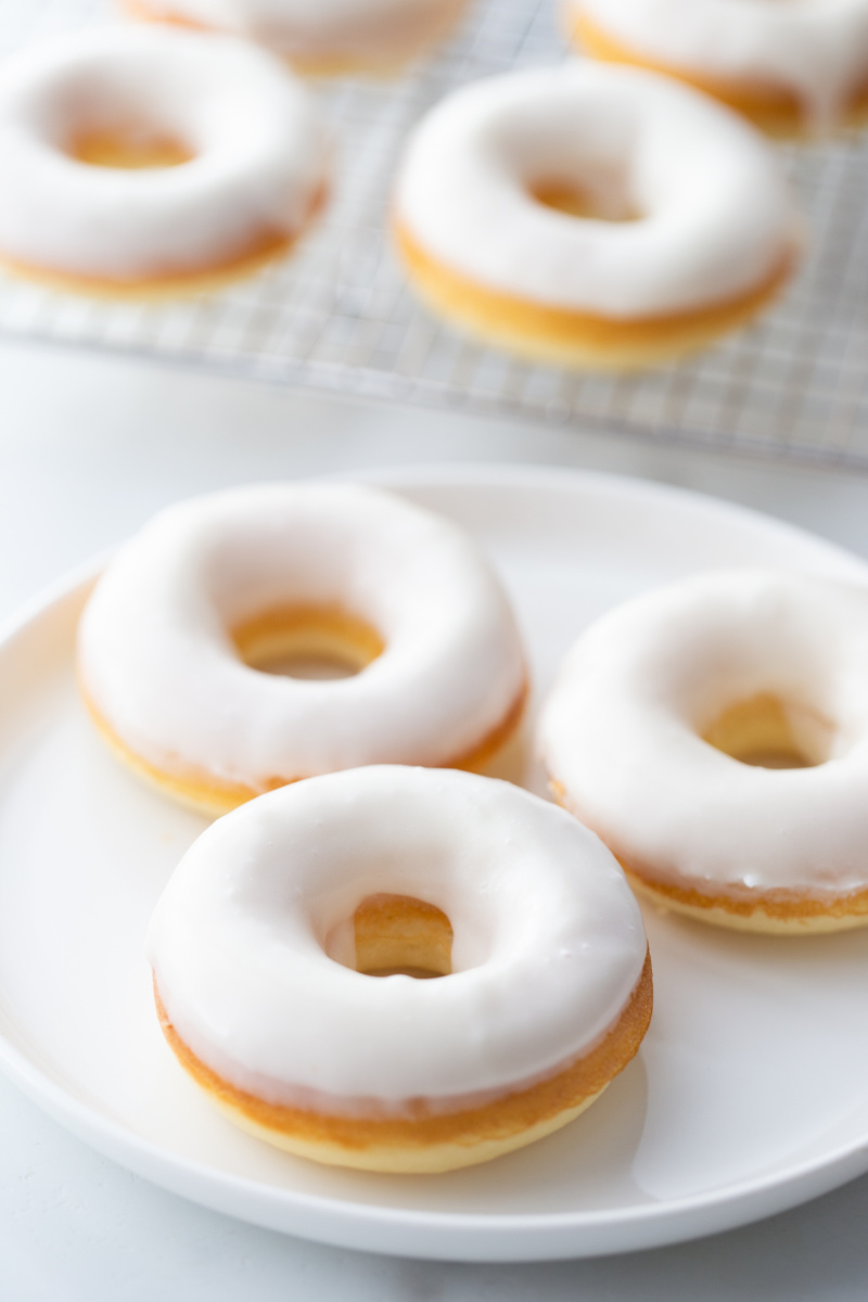 white glazed doughnuts on white plate