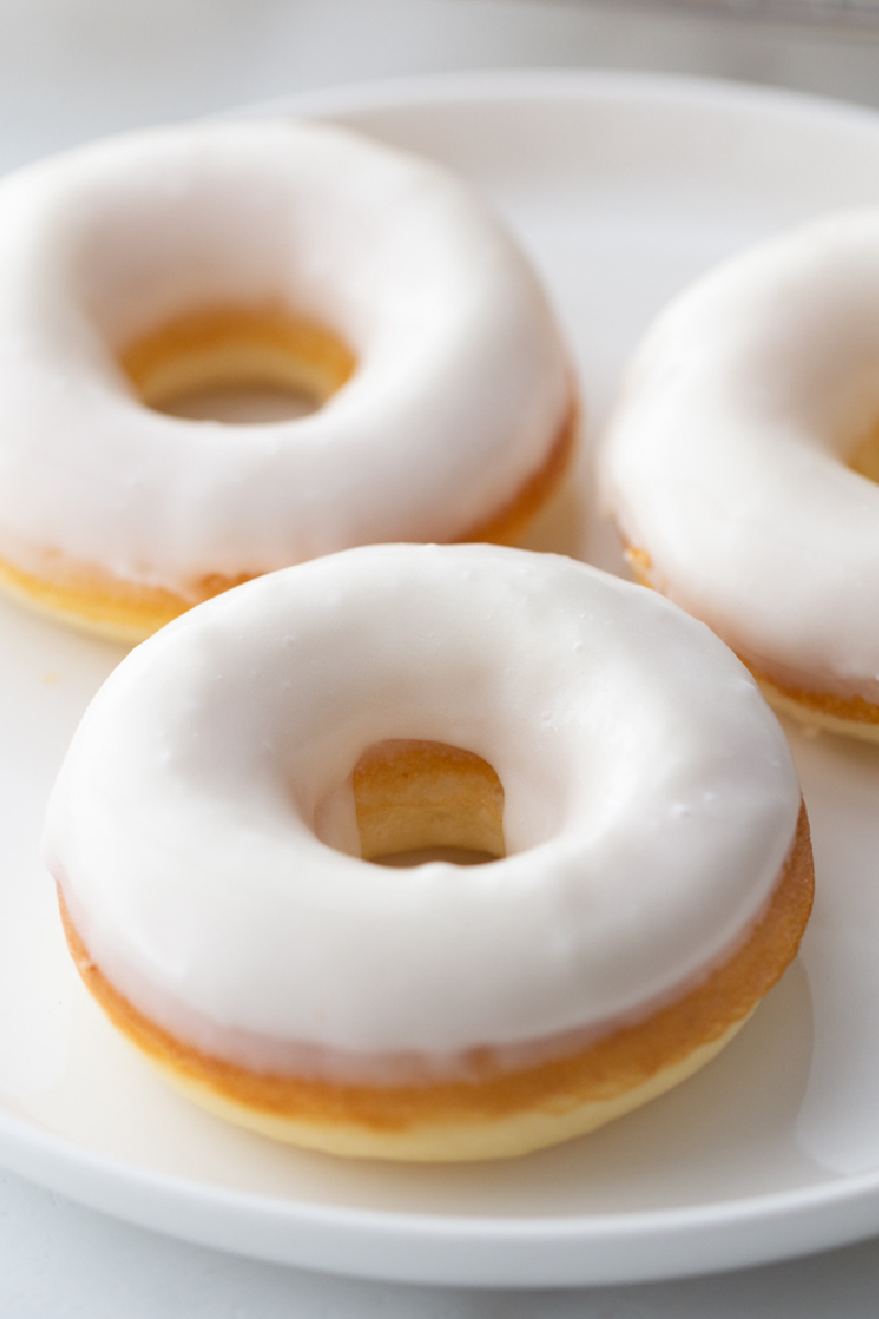 white glazed doughnuts on a white plate