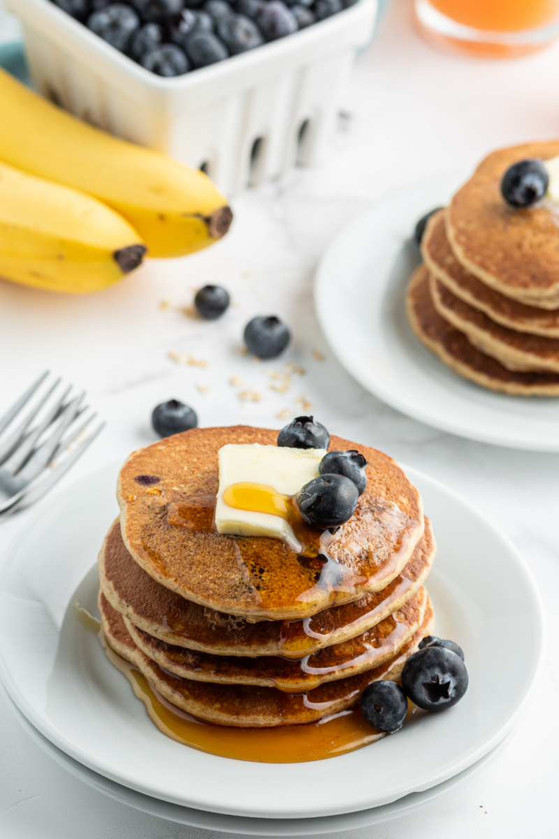 stack of blueberry pancakes with butter and syrup on top