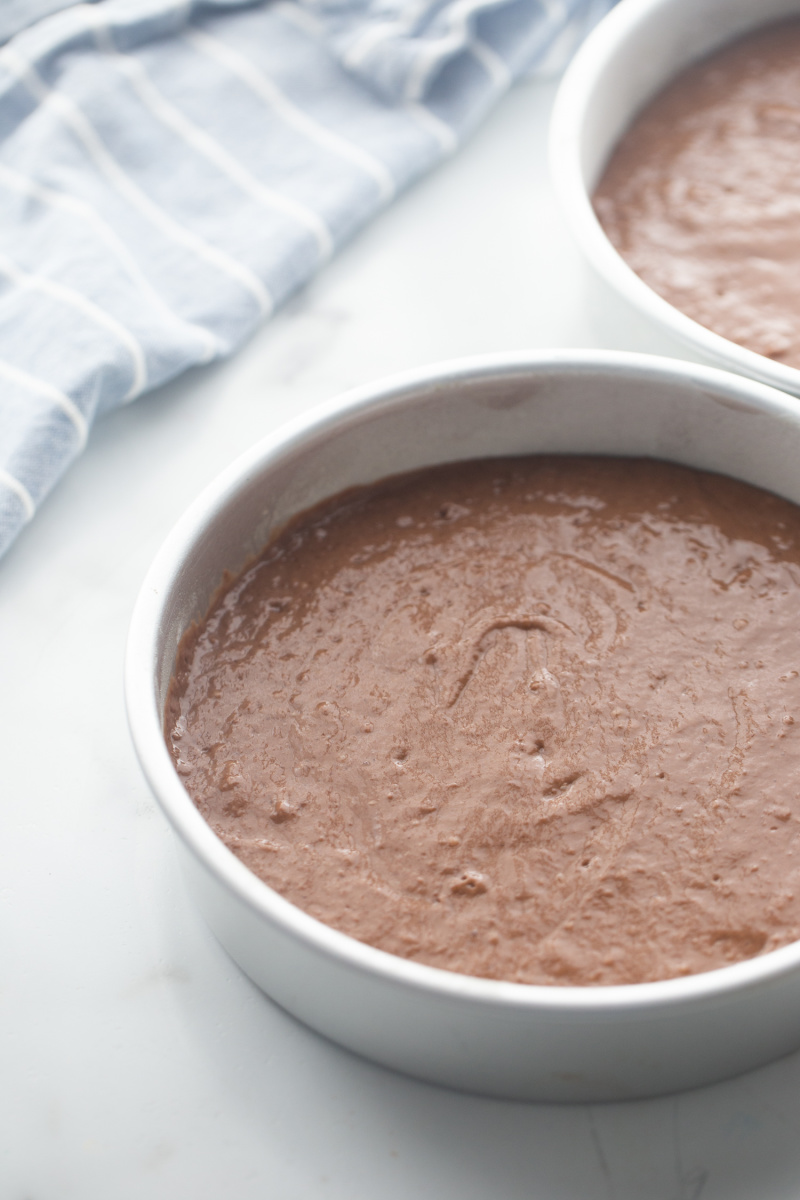 two pans with chocolate cake batter ready for oven