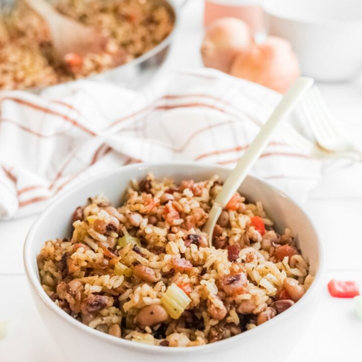 hoppin john in a white bowl with a spoon