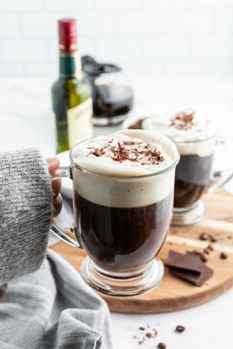 cozy sweater hand holding irish coffee in mug