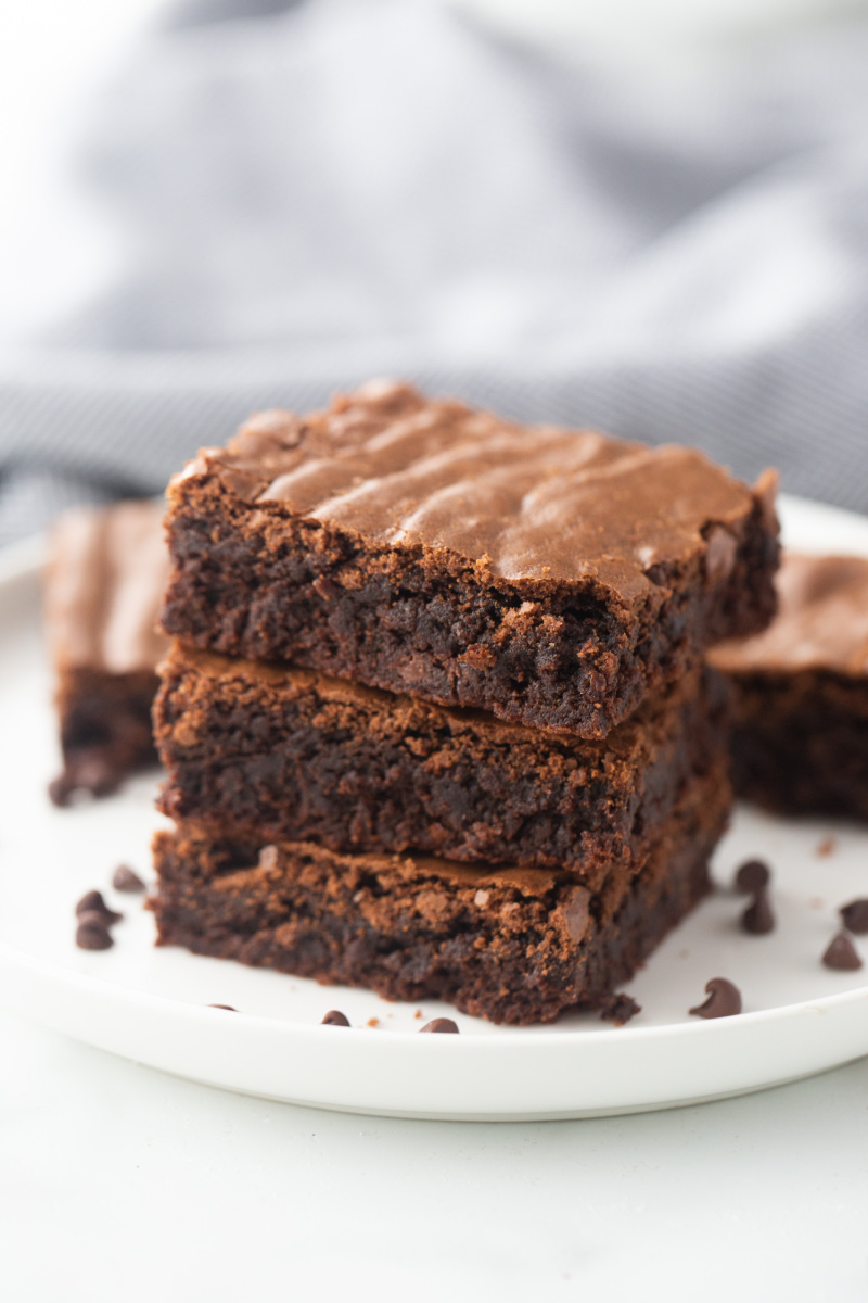 three brownies stacked on a white plate