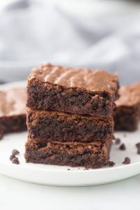 three brownies in a stack on a white plate