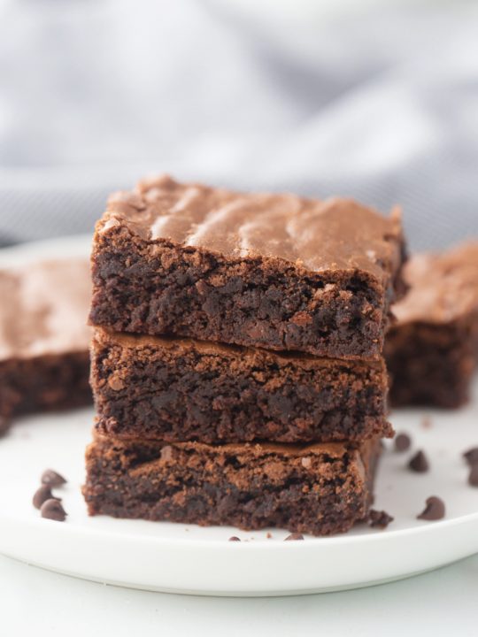 three brownies in a stack on a white plate