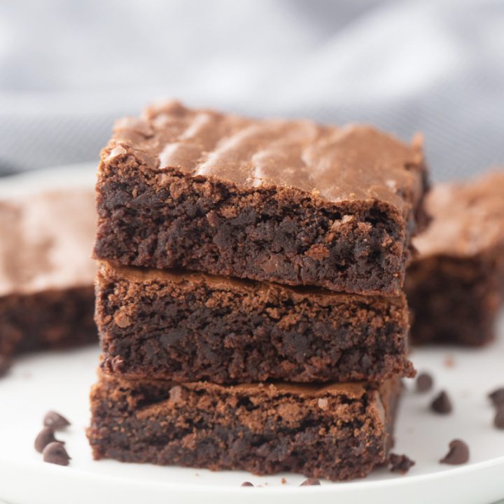 three brownies in a stack on a white plate