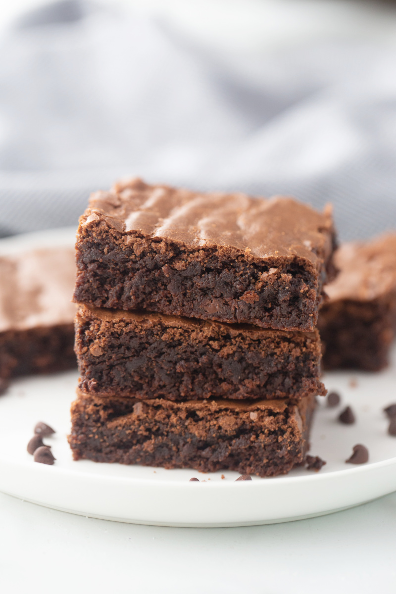 three brownies in a stack on a white plate