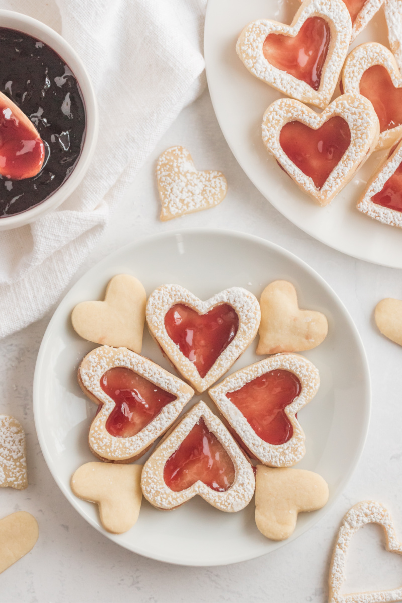 heart shaped raspberry linzer cookies on white plate