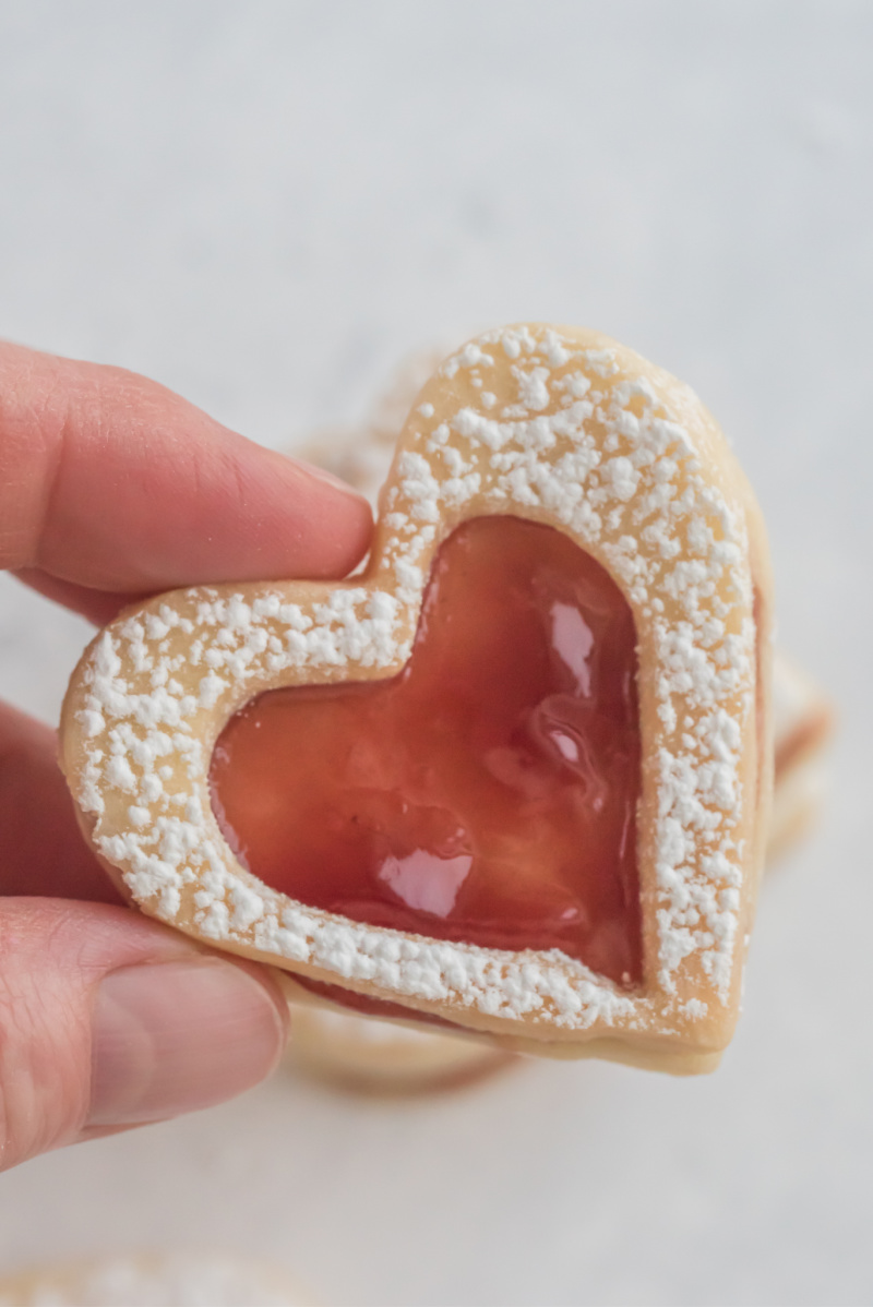 hand holding raspberry linzer cookie