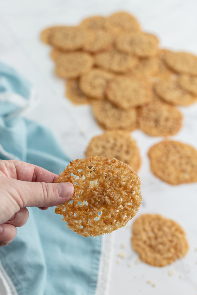 holding lacy oatmeal cookie