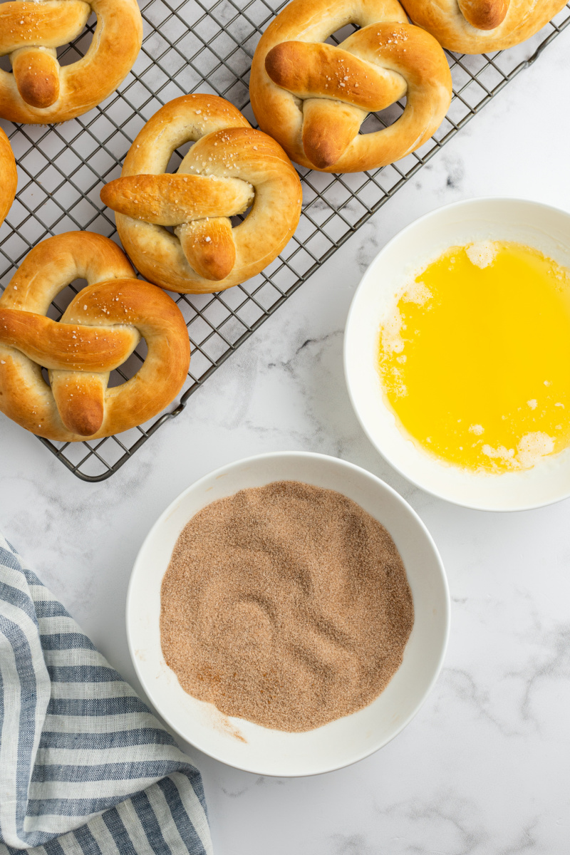 pretzels on a cooling rack ready to dip into butter, cinnamon and sugar