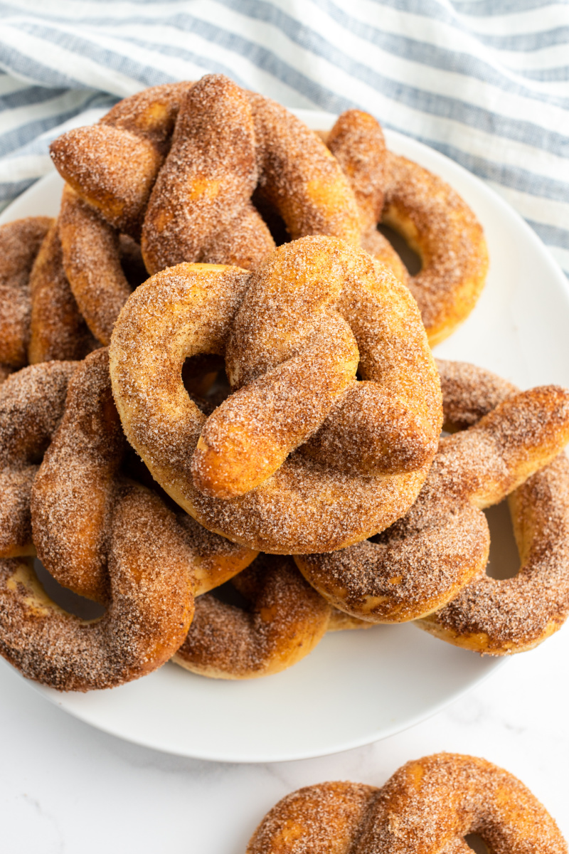 cinnamon sugar soft pretzels stacked on a white platter