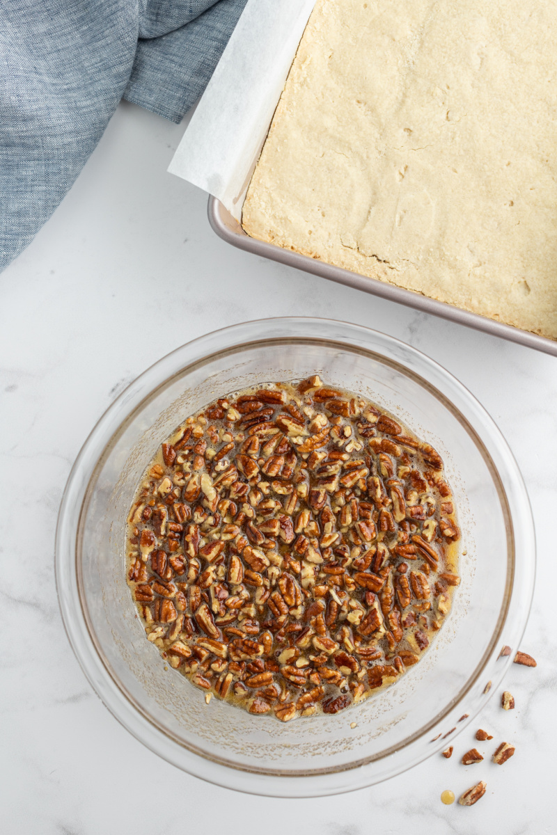 bowl of pecan filling and crust in a pan next to it