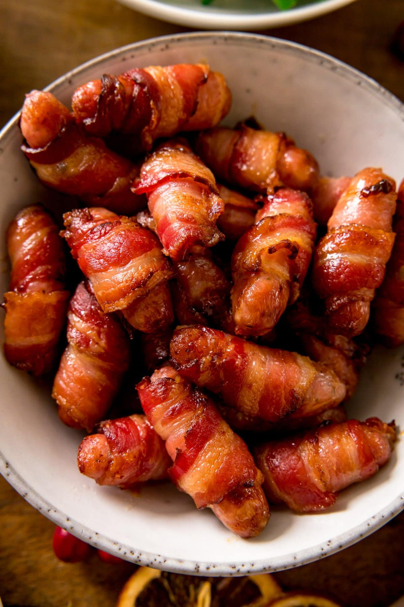 bacon wrapped pigs in a blanket in a white bowl