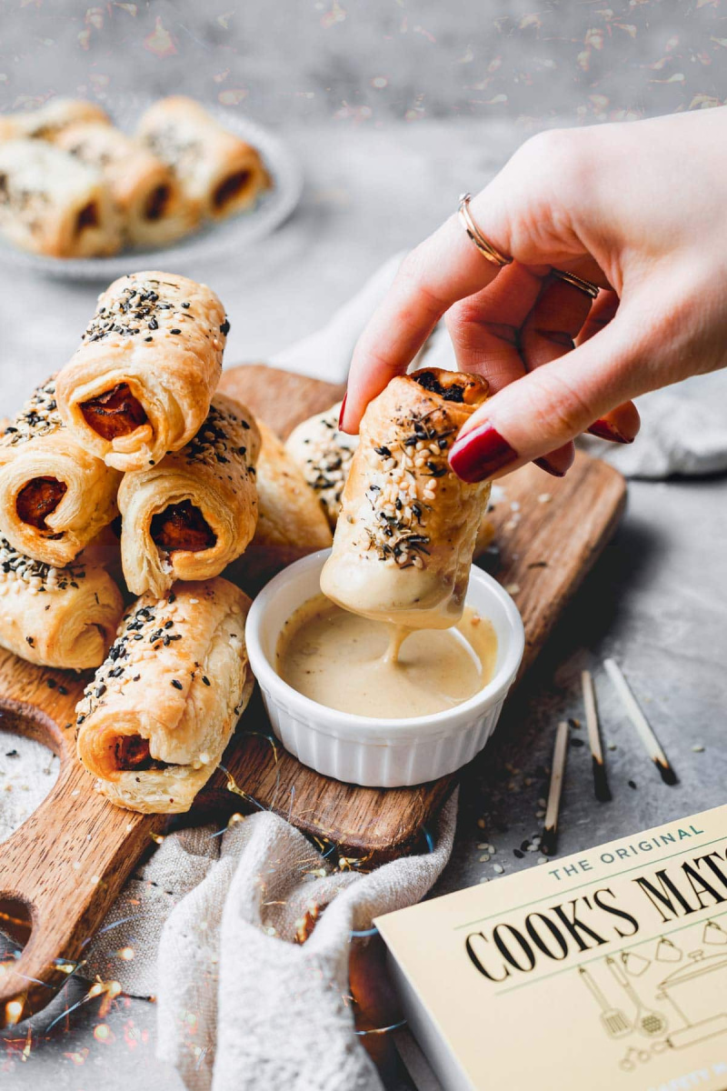 vegan pigs in a blanket displayed and dipping in sauce
