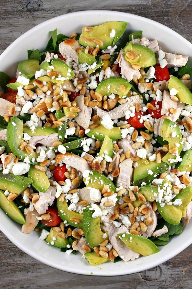 chicken spinach salad in white bowl