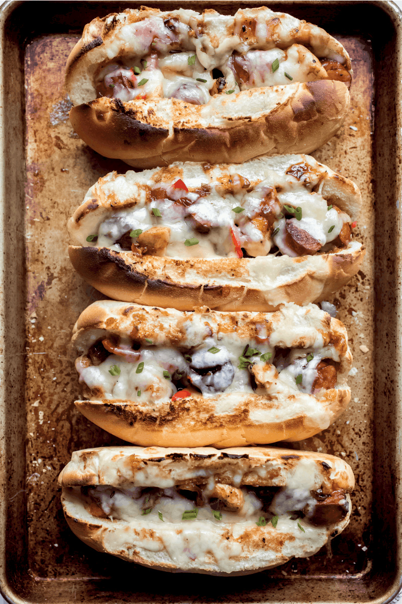 four chicken and sausage hoagies on a baking sheet