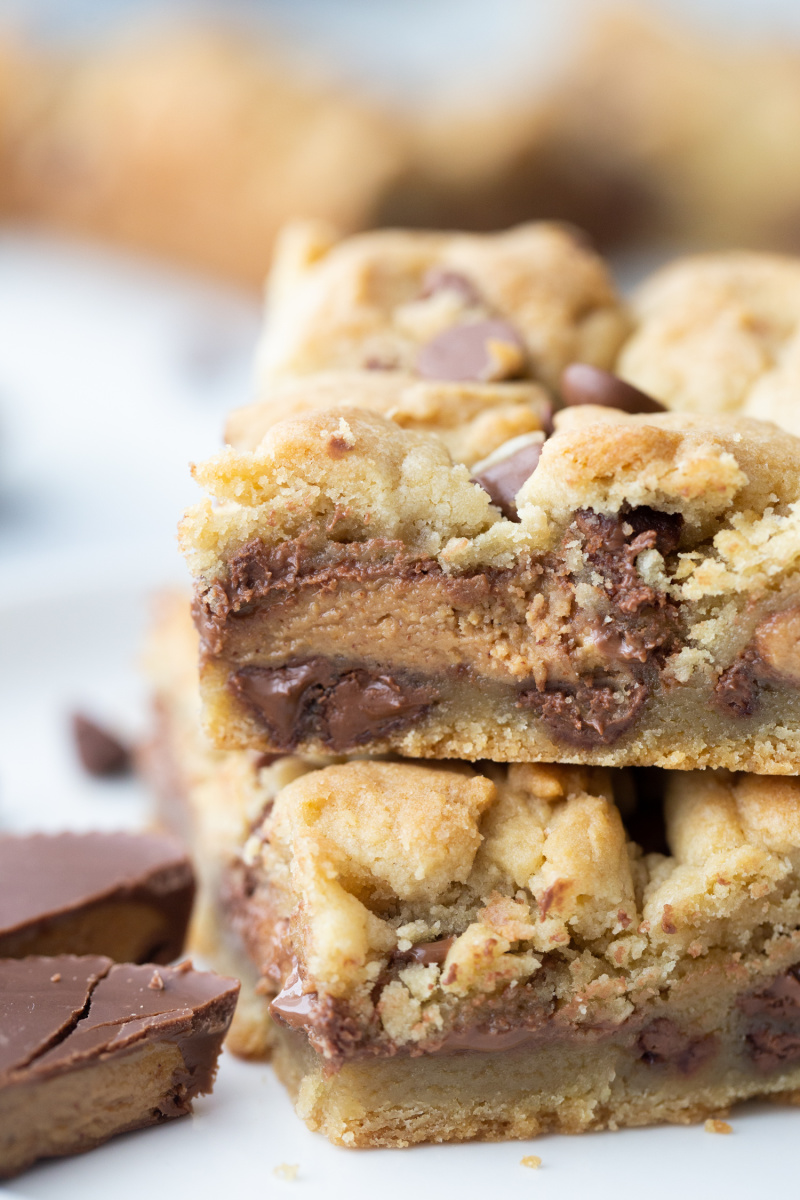 close up of two reeses stuffed chocolate chip cookie bars stacked