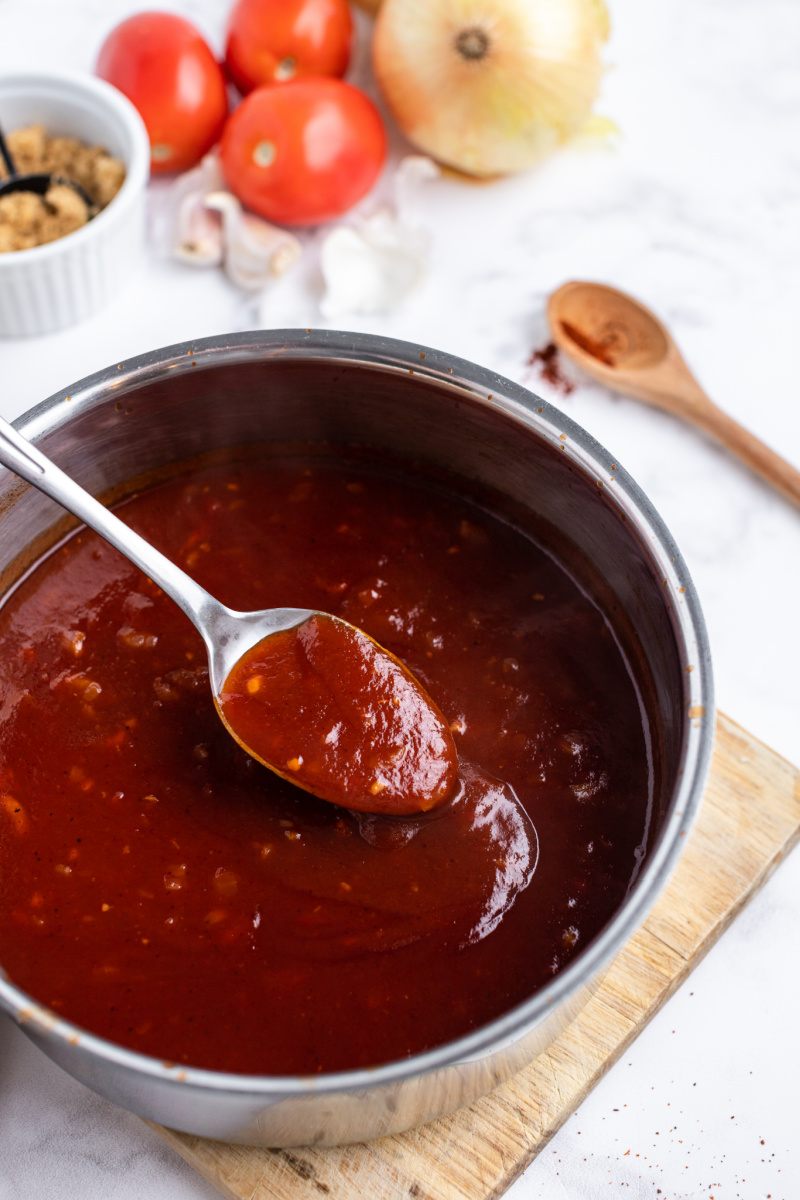 spoon taking barbecue sauce out of saucepan