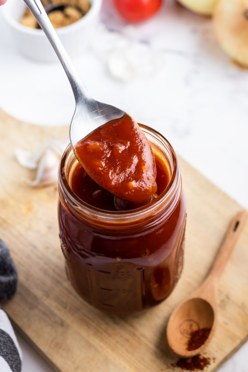 spoon taking barbecue sauce out of a jar