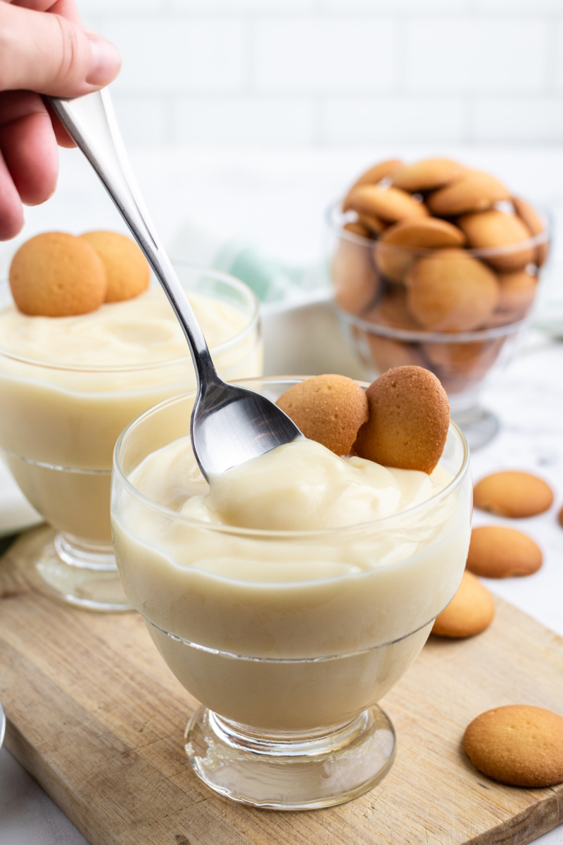 spooning vanilla pudding out of glass dish