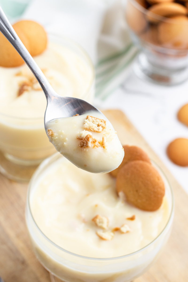 spooning vanilla pudding out of glass dish