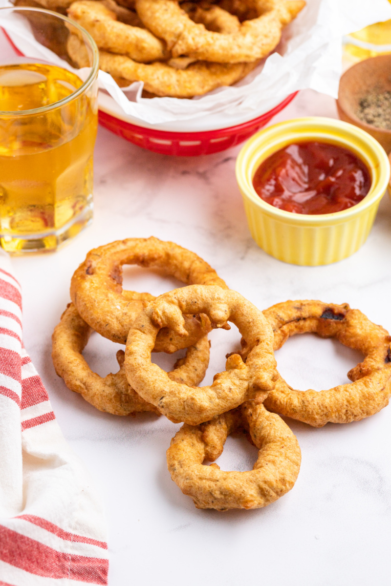 a few onion rings scattered on a table with ketchup