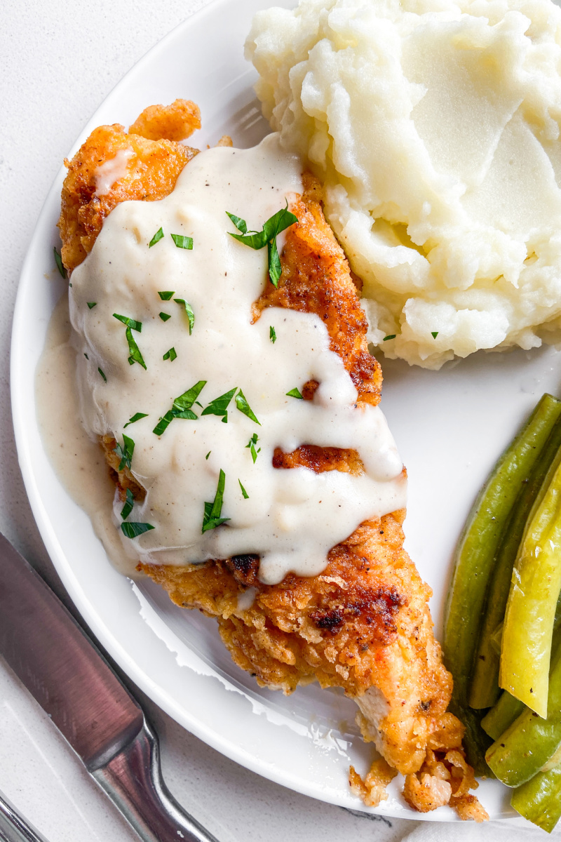 chicken fried chicken on a white plate with gravy