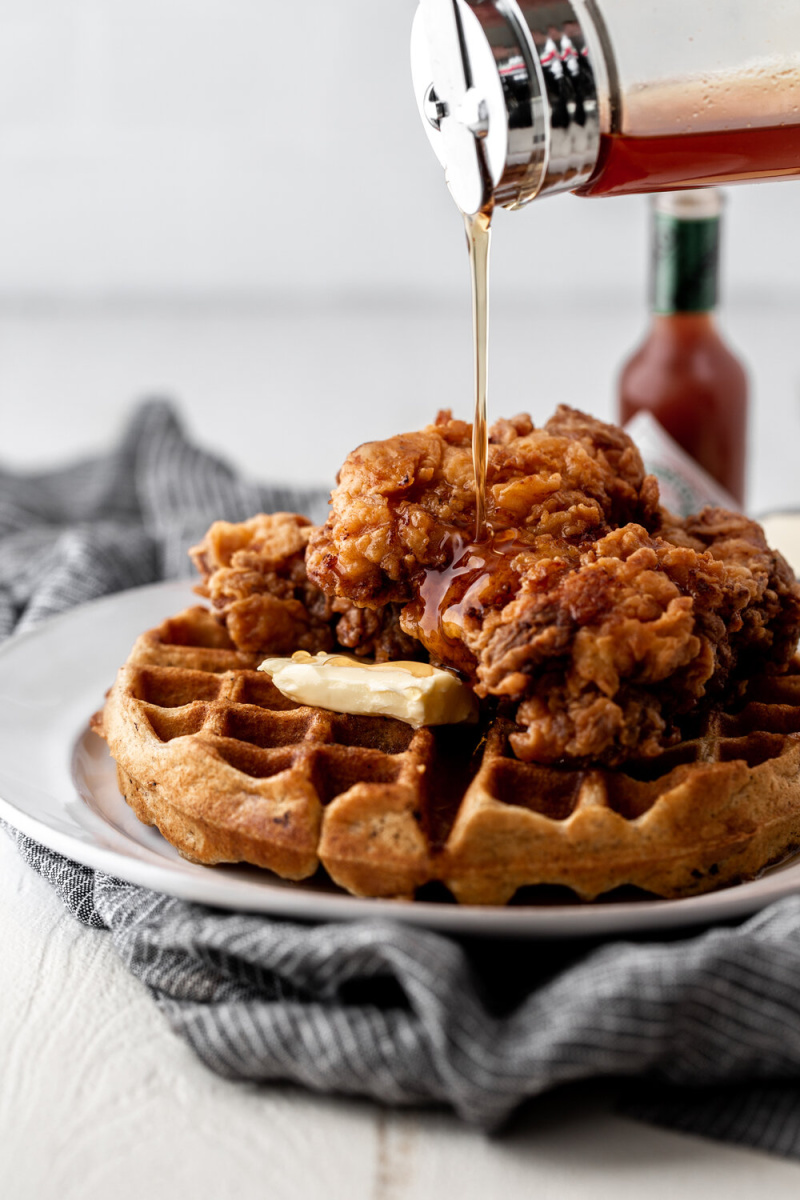 fried chicken and waffles with syrup poured over