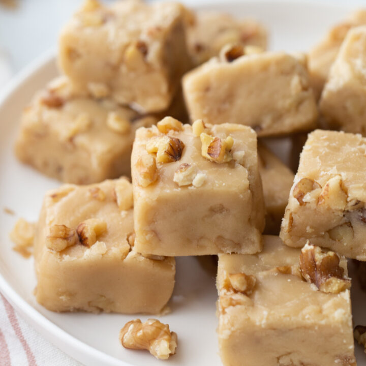 pieces of maple walnut fudge stacked on white platter