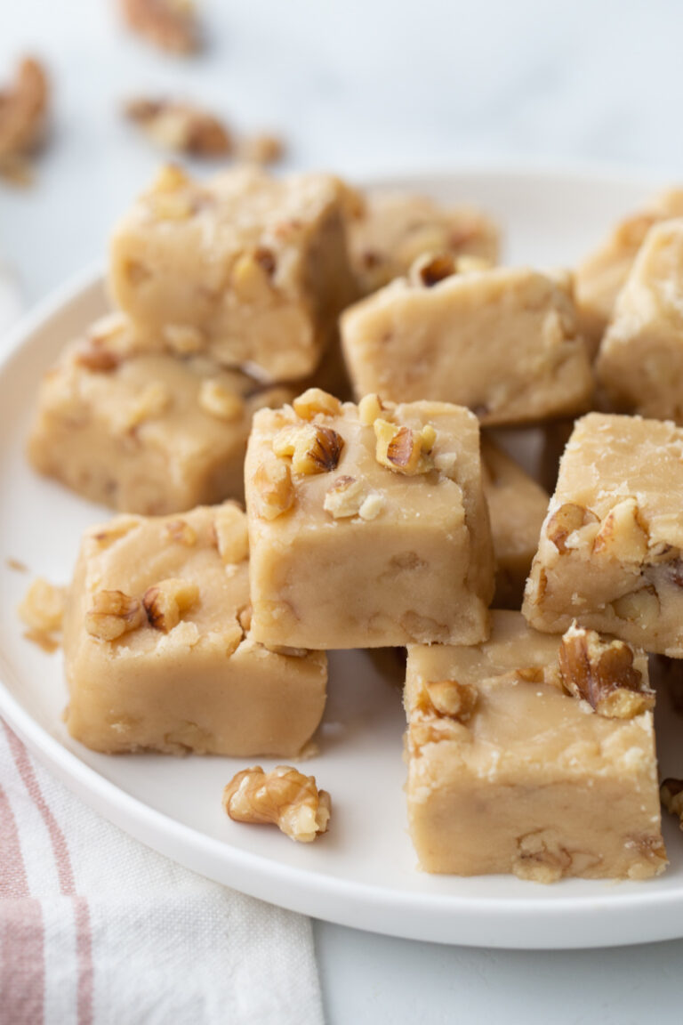 pieces of maple walnut fudge stacked on white platter