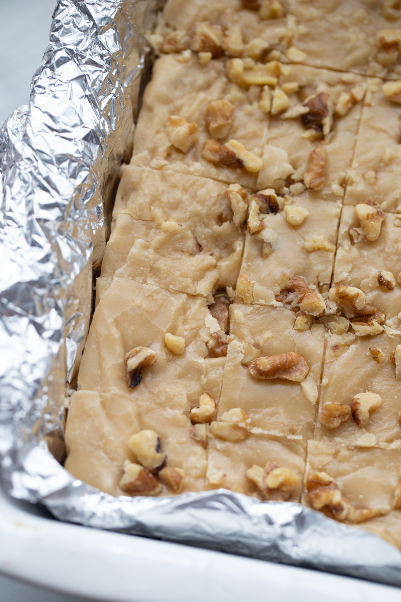 maple walnut fudge cut into pieces in foil lined pan
