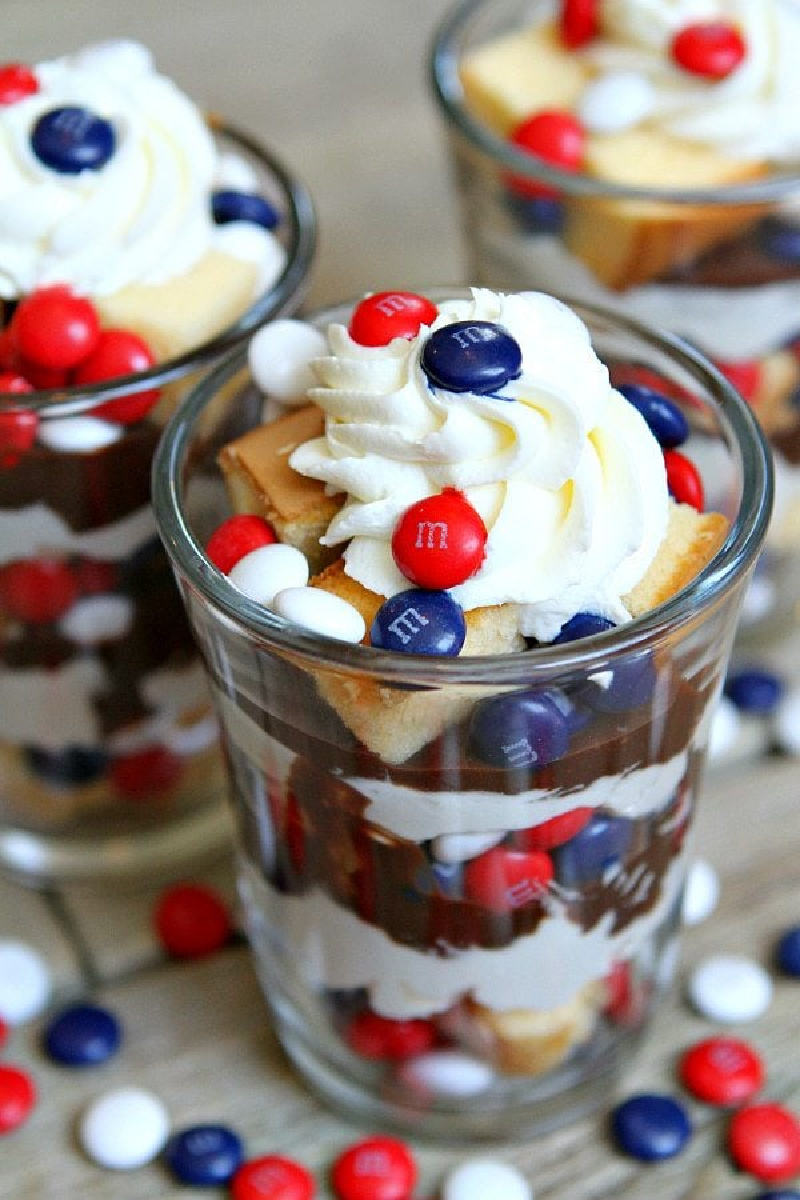glasses filled with red white and blue cheesecake trifles