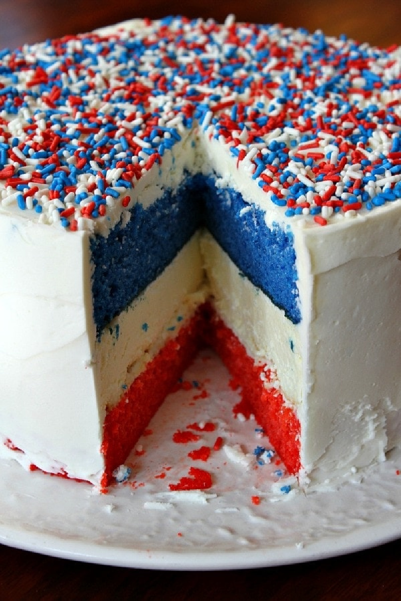 red white and blue cheesecake cake with slice taken out of it