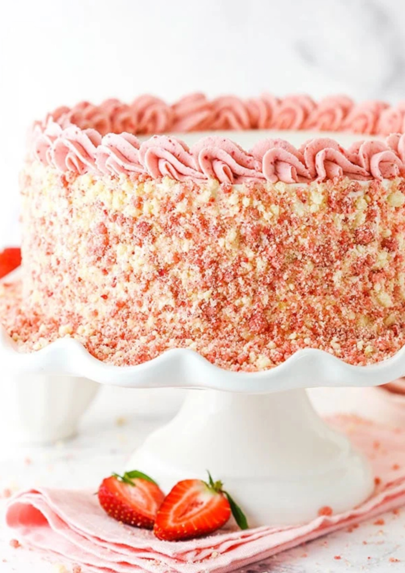 strawberry crunch ice cream cake on white cake platter