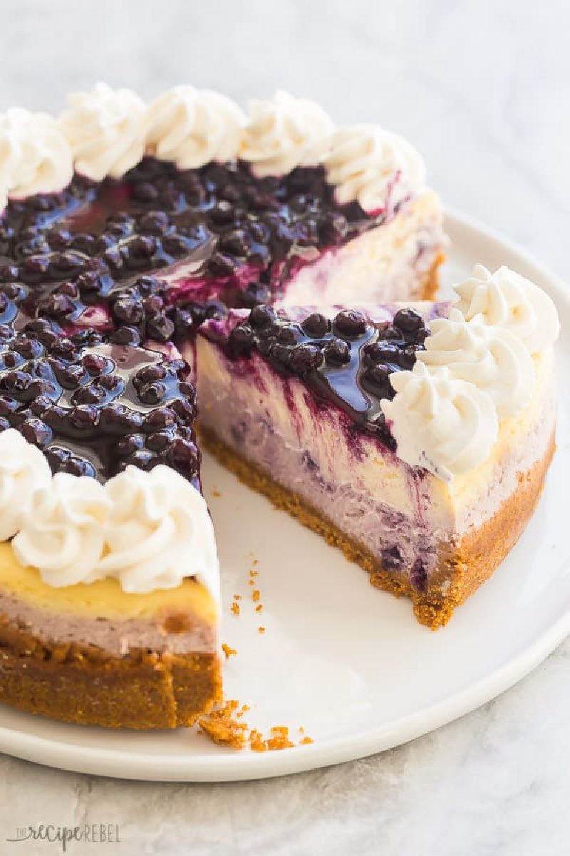 blueberry cheesecake with slice being taken out of it