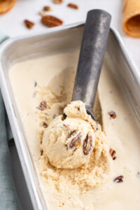 butter pecan ice cream in a container with an ice cream scoop