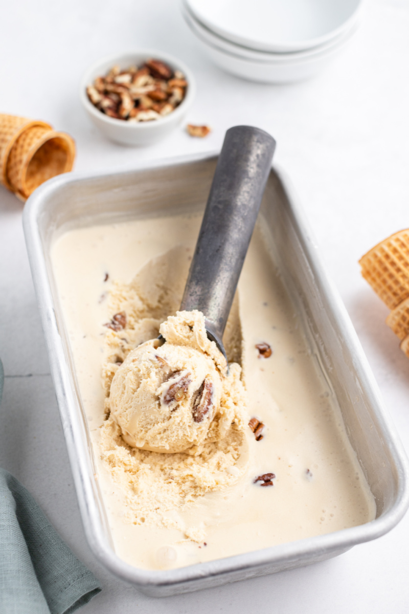 butter pecan ice cream in a container with an ice cream scoop