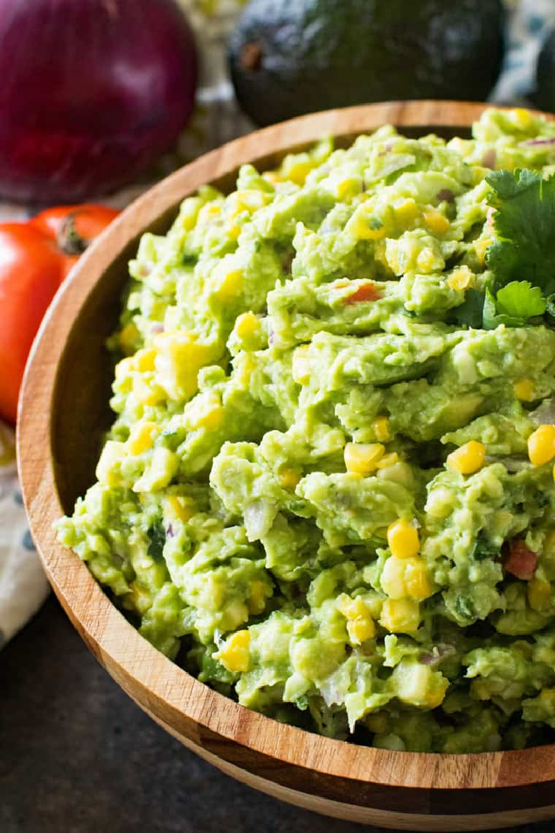 corn guacamole in a wood bowl