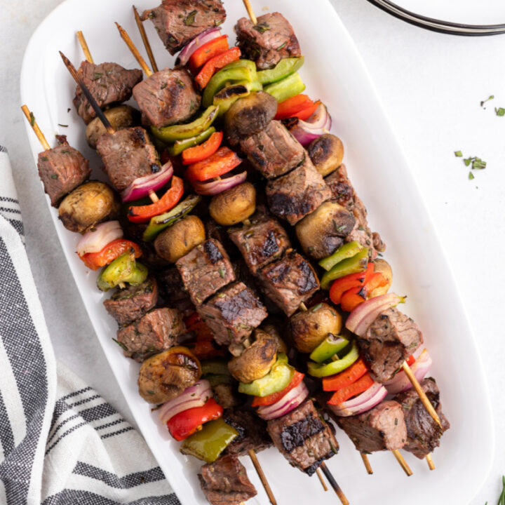 grilled lemon garlic steak kebabs on a white platter