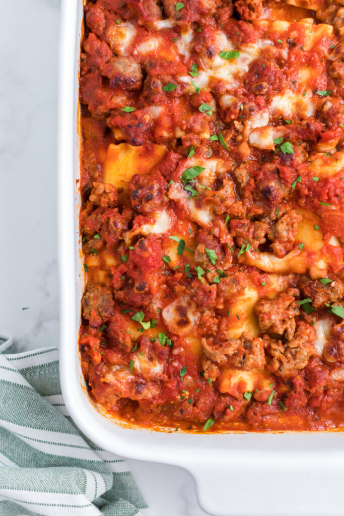 italian sausage lasagna roll ups in a white casserole dish