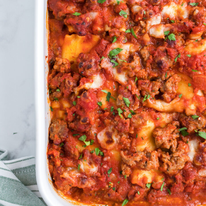 italian sausage lasagna roll ups in a white casserole dish