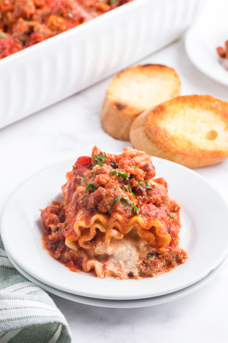 italian sausage lasagna roll up on a white plate