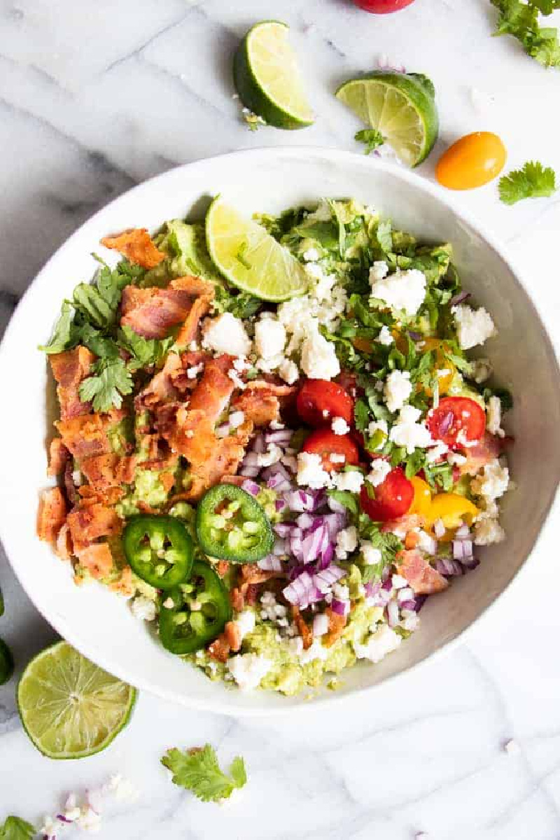 loaded guacamole in a white bowl