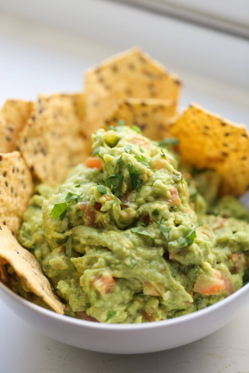 guacamole in a white bowl with chips