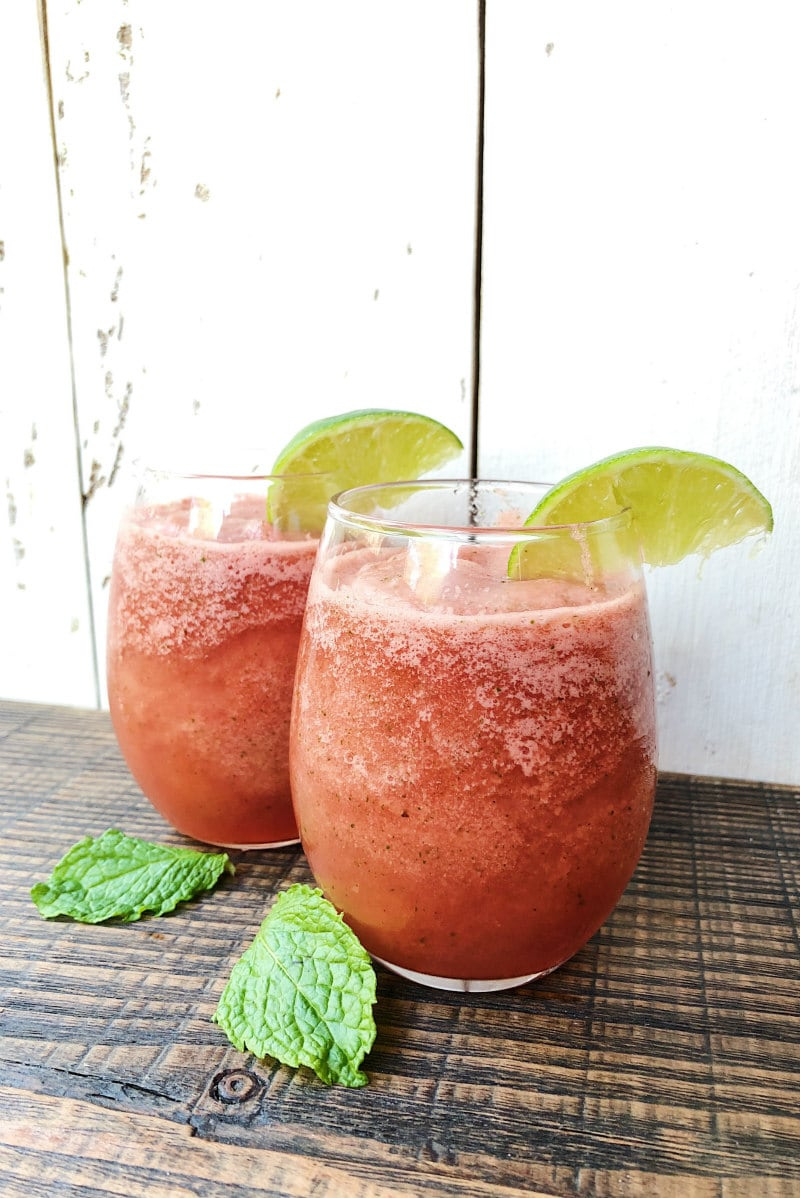 two slushy watermelon mojitos with lime garnish