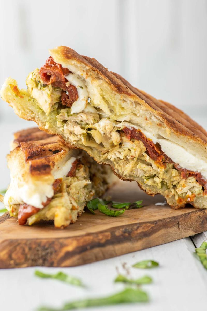 slices of chicken pesto panini on cutting board