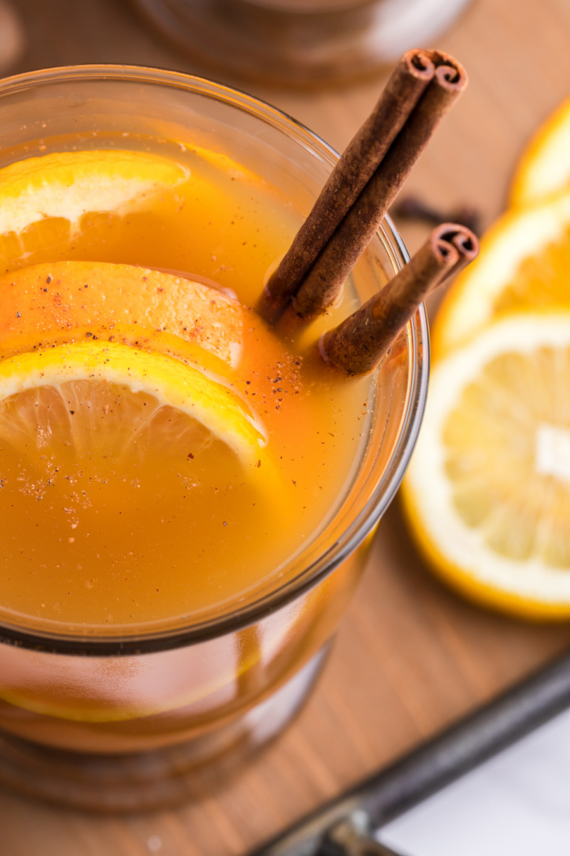 mulled cider in a mug with orange and cinnamon sticks