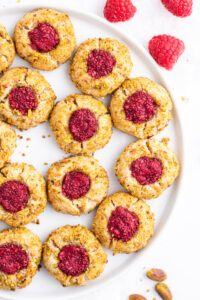 raspberry pistachio thumbprint cookies on a platter